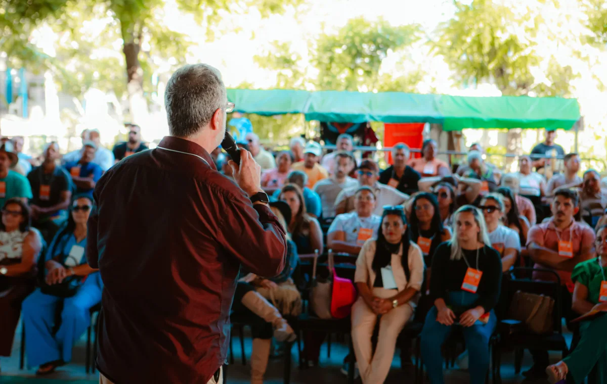 Palestrante fala ao microfone para uma plateia sentada no palco da Agência Sebrae na Festa do Boi