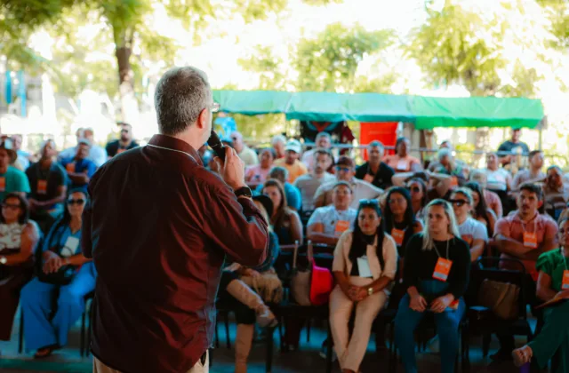 Palestrante fala ao microfone para uma plateia sentada no palco da Agência Sebrae na Festa do Boi